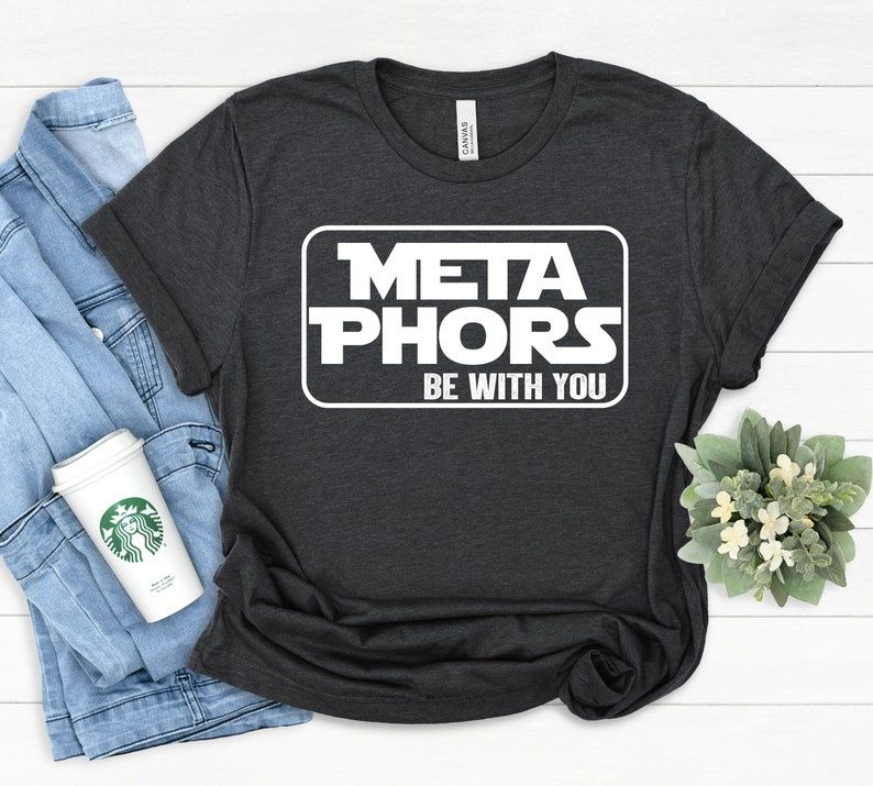 Image of a black t-shirt with the Star wars font reading "Meta Phors be with you."