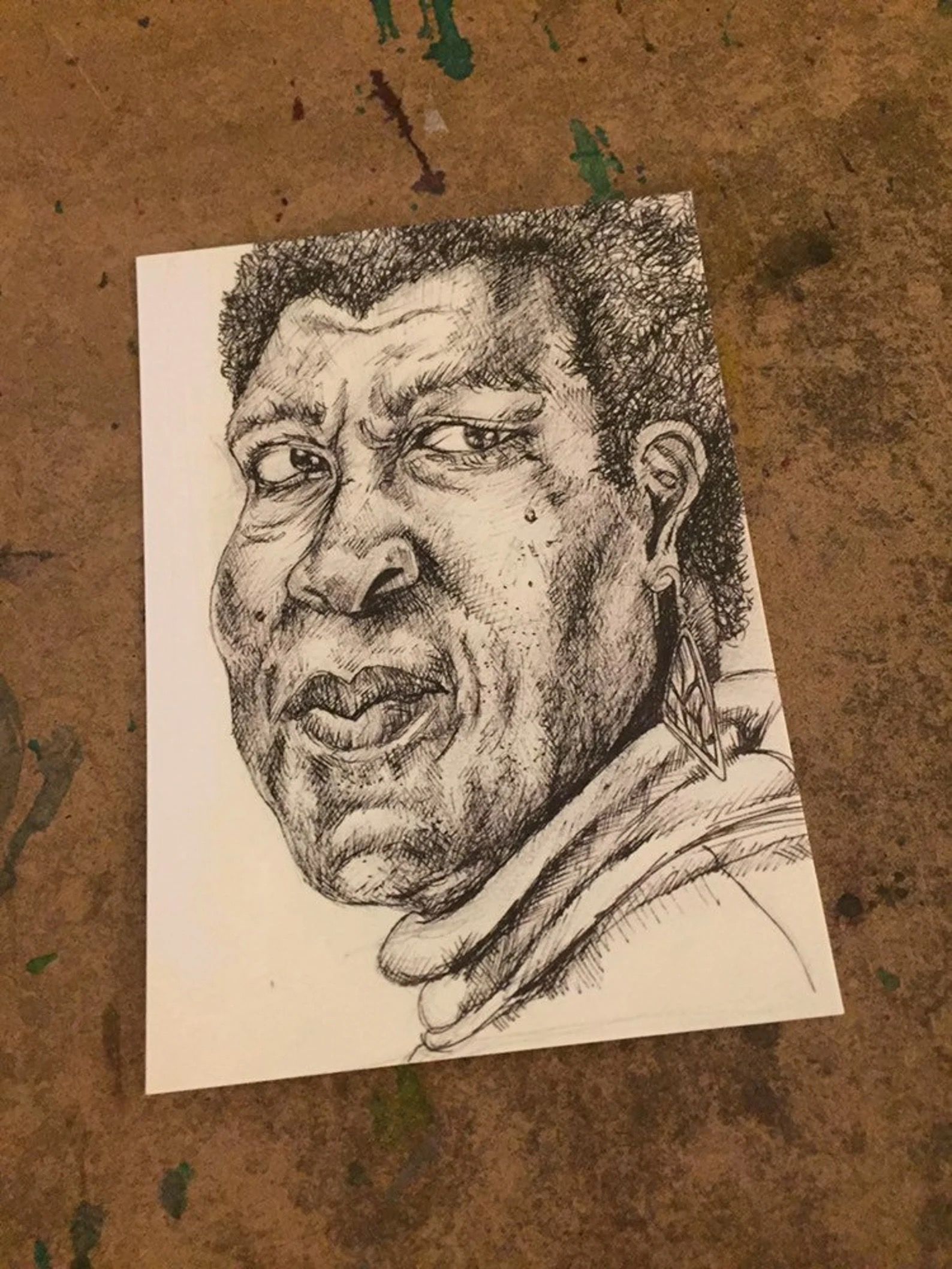 Postcard with a black and white ink sketch of Octavia Butler's face.