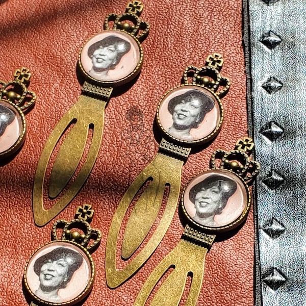 five brass bookmarks featuring images of Zora Neale Hurston beneath a magnifying glass dome