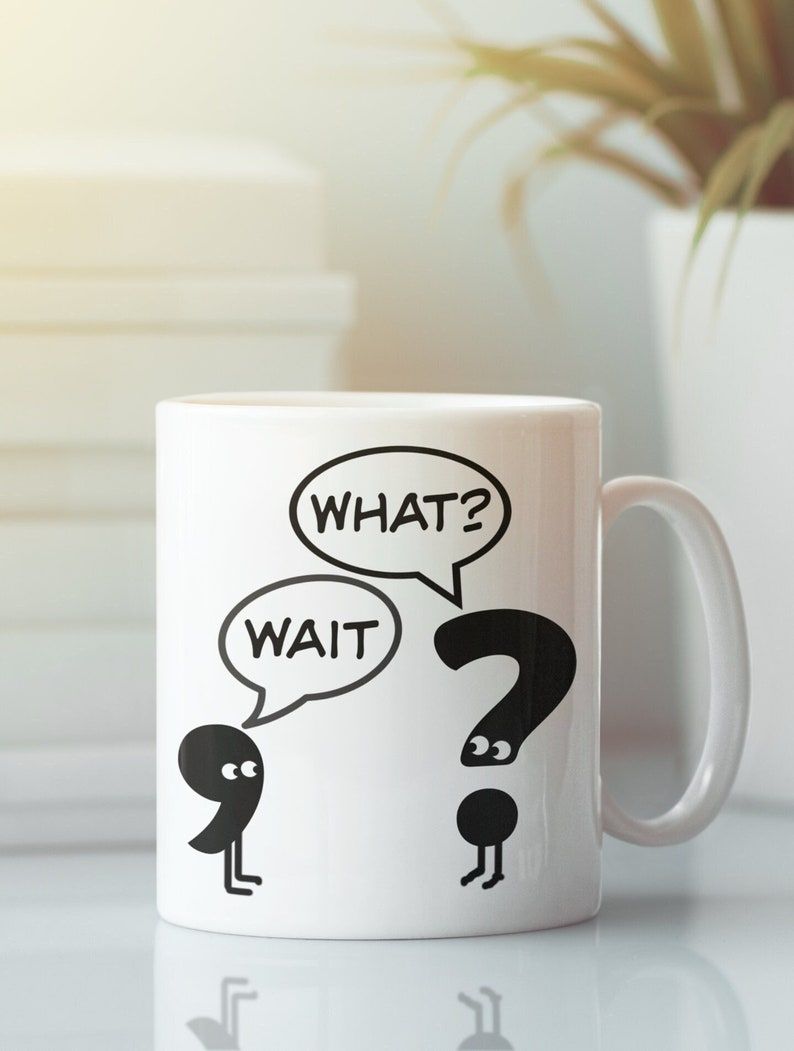 Image of a white mug. It has a comma with the speech bubble above it "wait," and the comma is in conversation with a question mark with the speech bubble "what?"