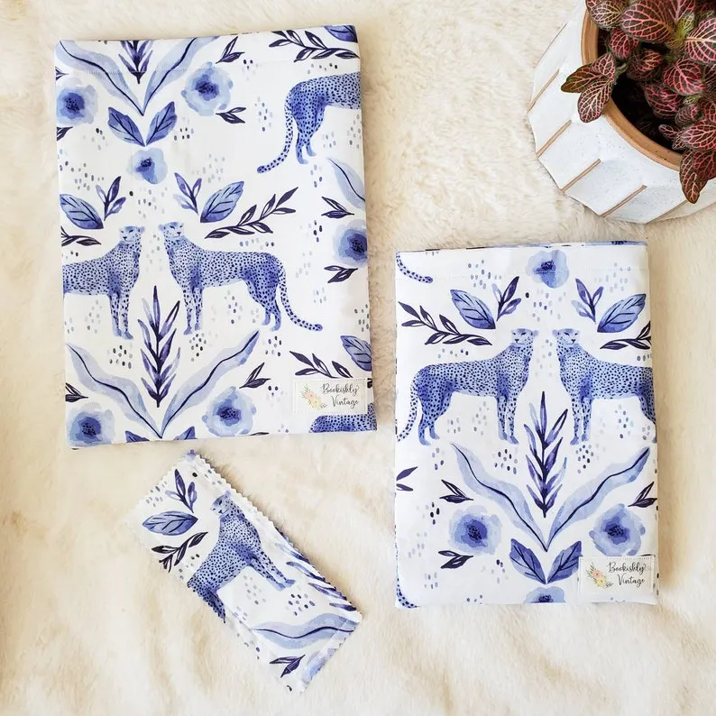 Image of three book sleeves in a blue pattern, featuring leopards.