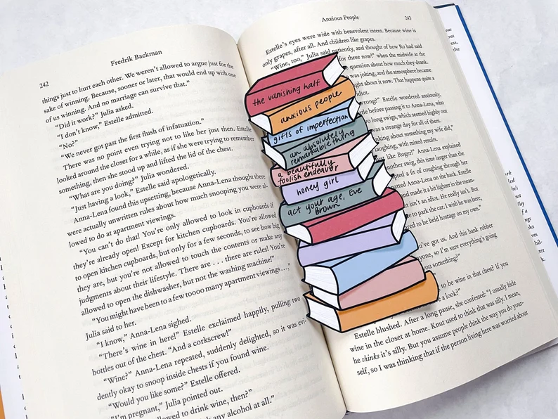 Image of a bright stack of books bookmark inside an open book. 