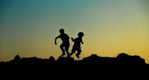 silhouette of two children playing at dusk