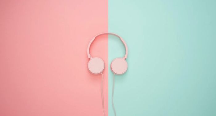 pink headphones set against a background that is pink on the left and mint green on the right