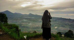 woman wearing a hijab looking off a cliff into the distance