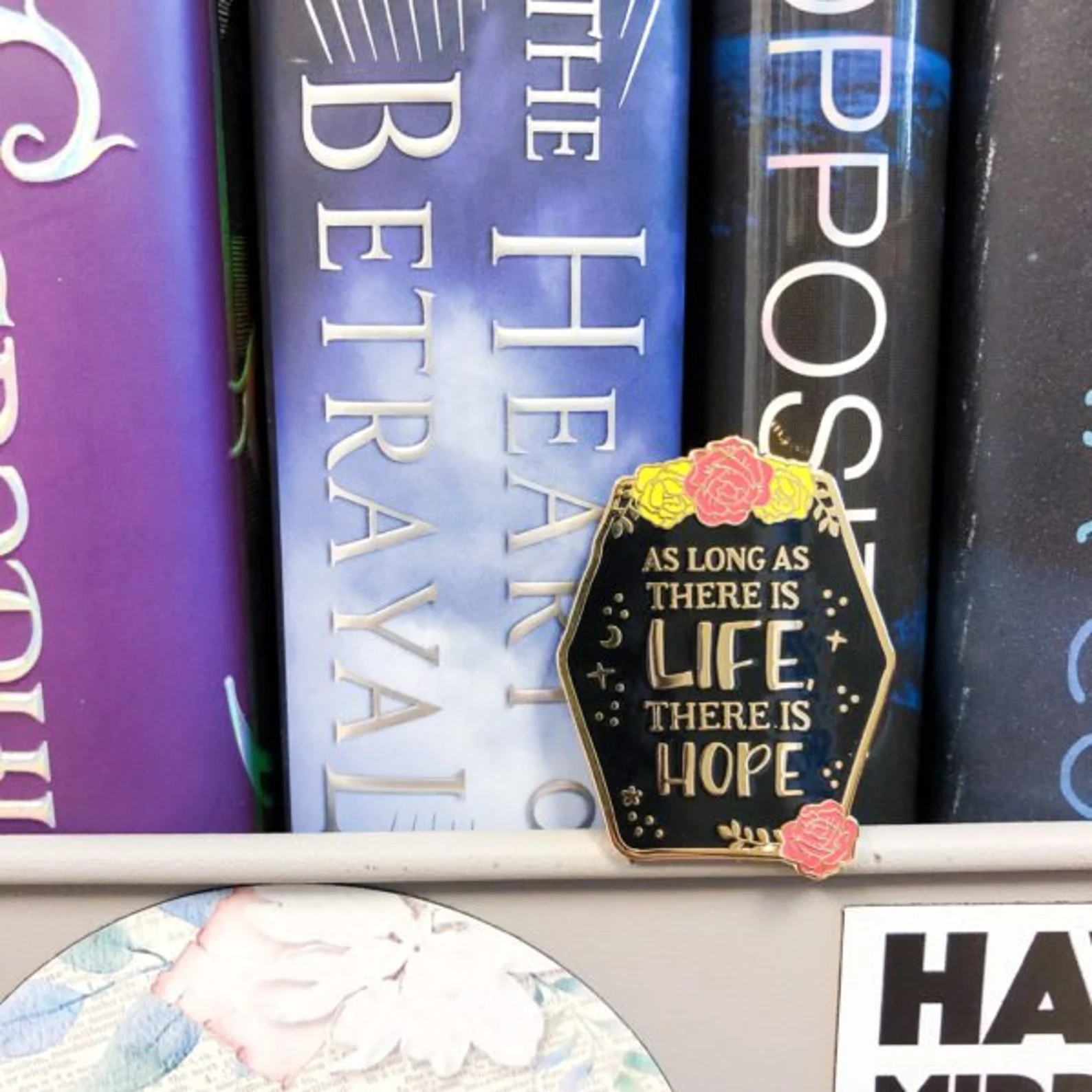 An enamel pin that reads "As long as there is life there is hope"