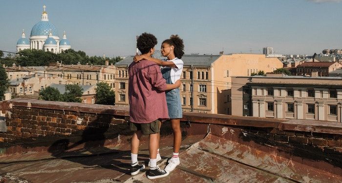 a photo of a teenage couple dancing on a rooftop