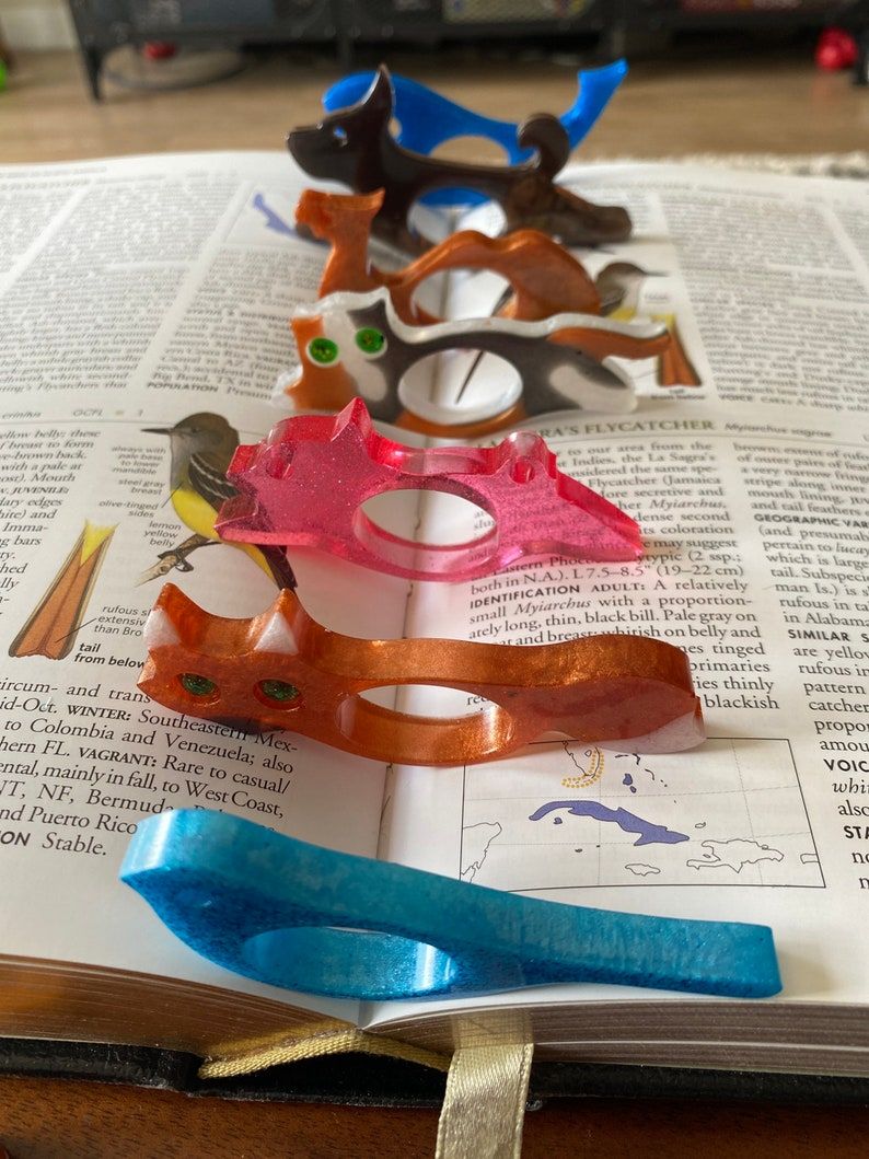 Many differently shaped book page holders line the gutter of a book in a rainbow of colors. 