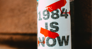 a photo of a poster on a pole reading 1984 is now with red security camera illustrations