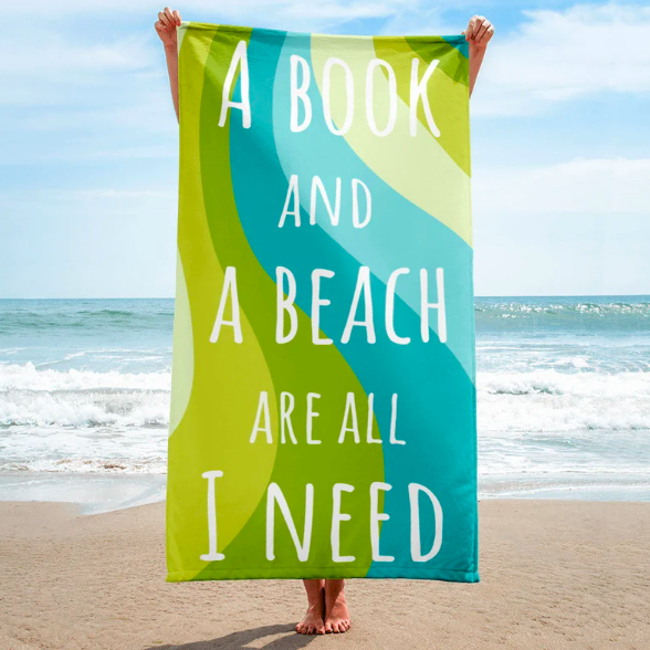 Person on a beach holding up a green and blue beach towel with text 