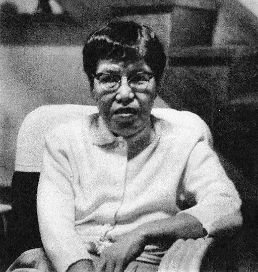 a black and white photo of an elder Nobuko Yoshiya sitting in a chair