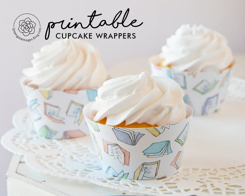Image of three cupcakes in cupcake holders that are decorated with pastel books. 