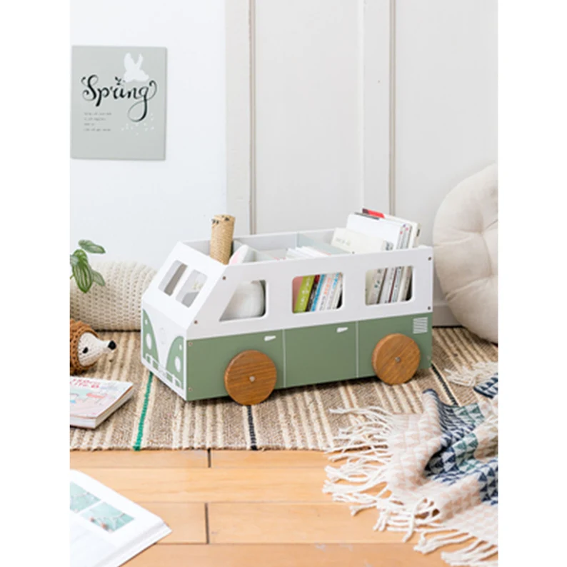 Image of a VW style bus in green and white. It is loaded with children's books in a children's bedroom. 