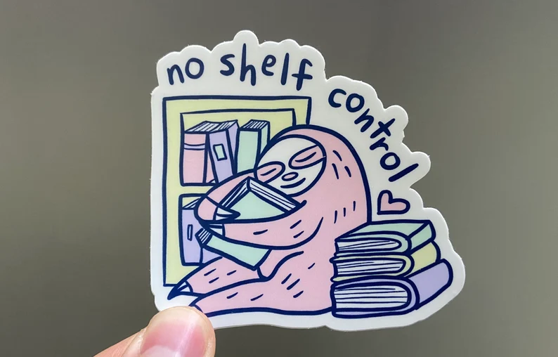 Image of a sticker featuring a sloth hugging a book. The sloth is in front of a bookshelf and beside a stack of books. The black text reads "no shelf control."