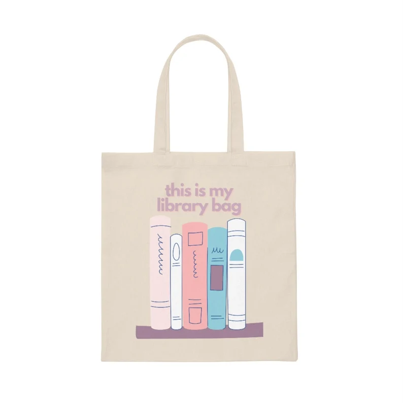 Image of a canvas tote bag. it has five pastel books on it. In light purple font the text reads "this is my library bag."