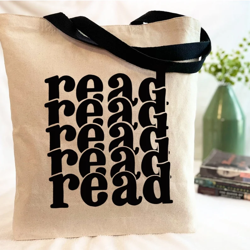 Image of a canvas tote with black handles. In black font, the word "read" is repeated.