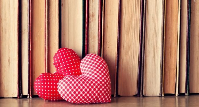 two cloth hearts placed in front of a row of books