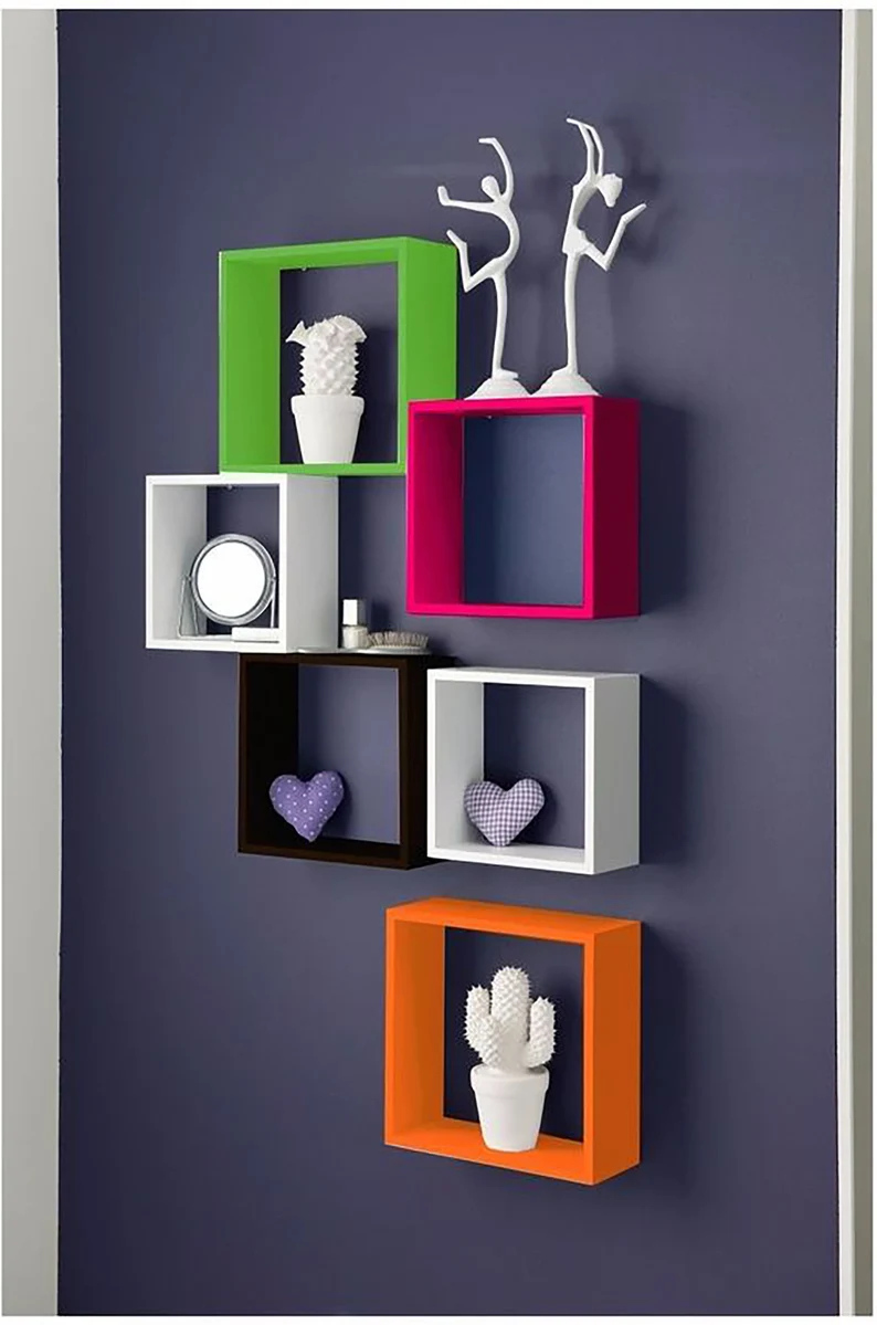 Image of six colorful book shelves in the shape of cubes. They are hanging on a dark blue wall. 