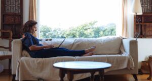 person sitting on a sofa working on a laptop computer