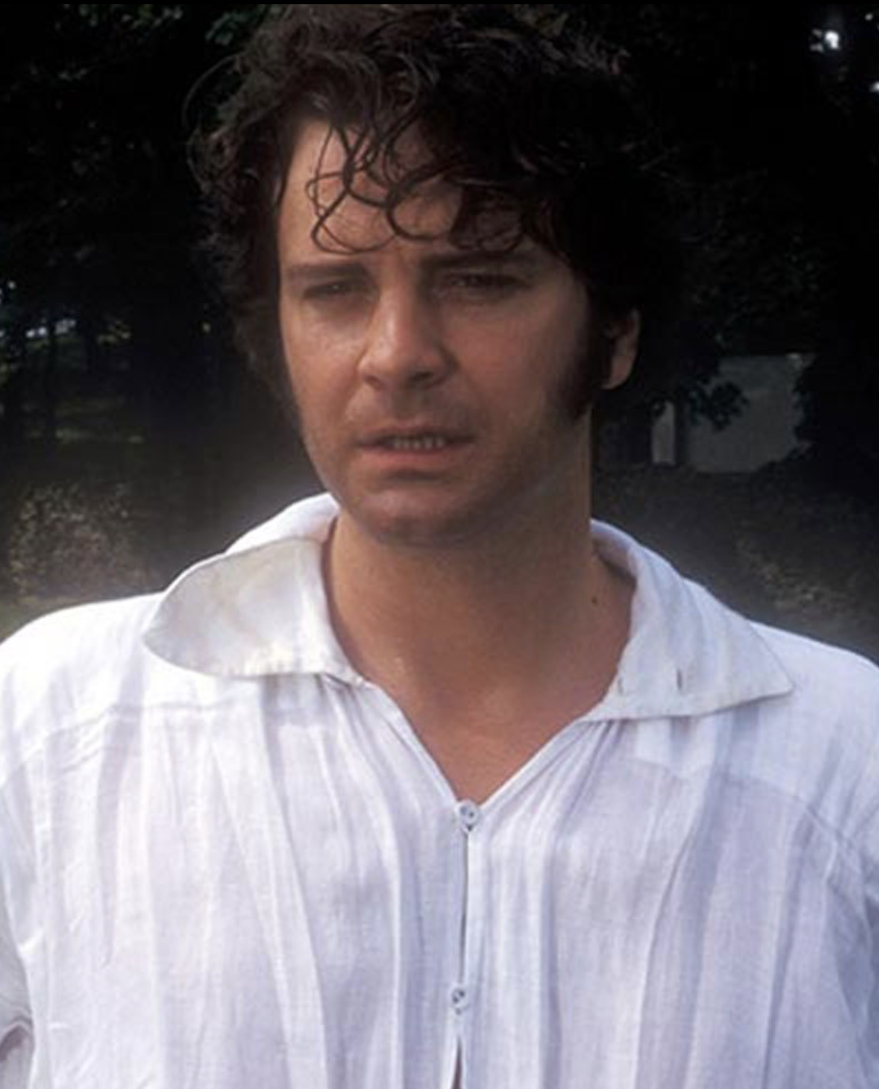 Colin Firth as Mr. Darcy in a collared white linen shirt that is soaking wet because he has just emerged from a pond. 