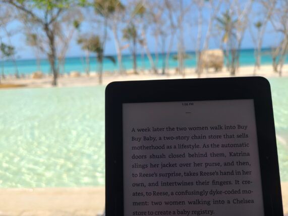 Ereader with a pool and beach in the background