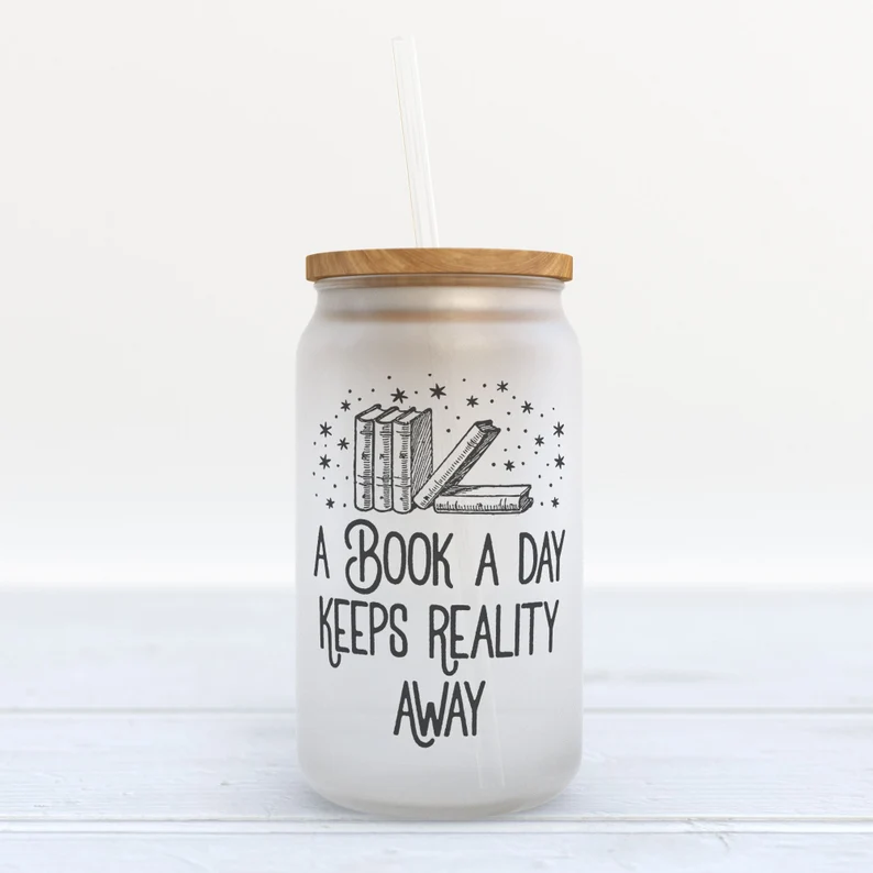 Image of a glass tumbler. It has black text which reads "a book a day keeps reality away."