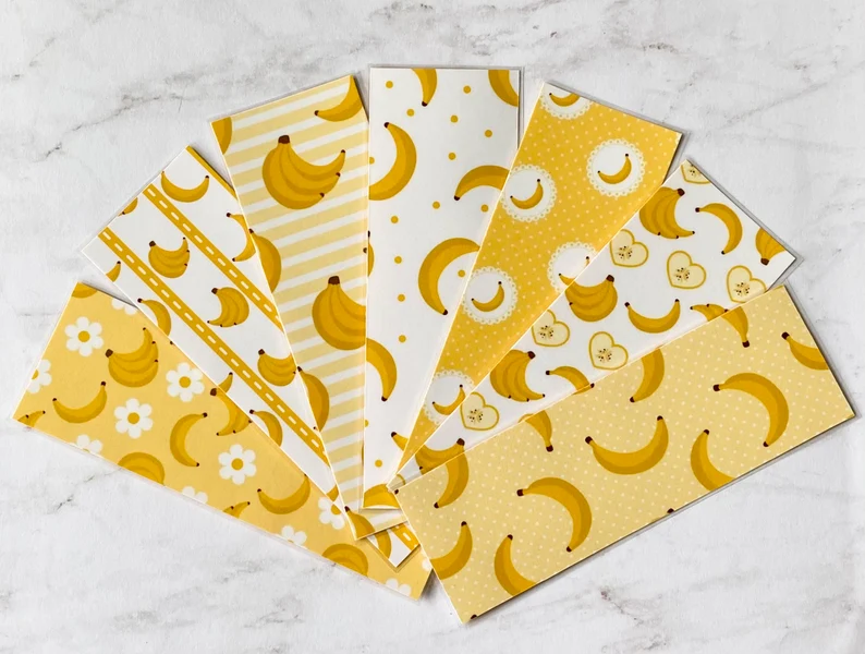 Image of an array of yellow and white banana-themed bookmarks. 