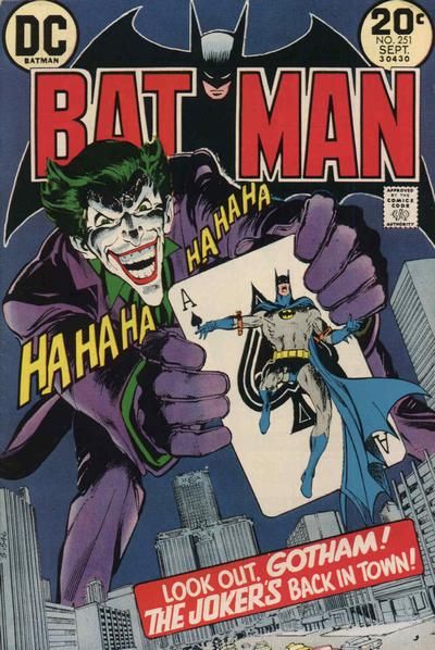 The cover to Batman #251. A giant Joker looms over Gotham, laughing and holding a huge playing card with Batman strapped to it. The caption reads "Look out, Gotham! The Joker's back in town!"