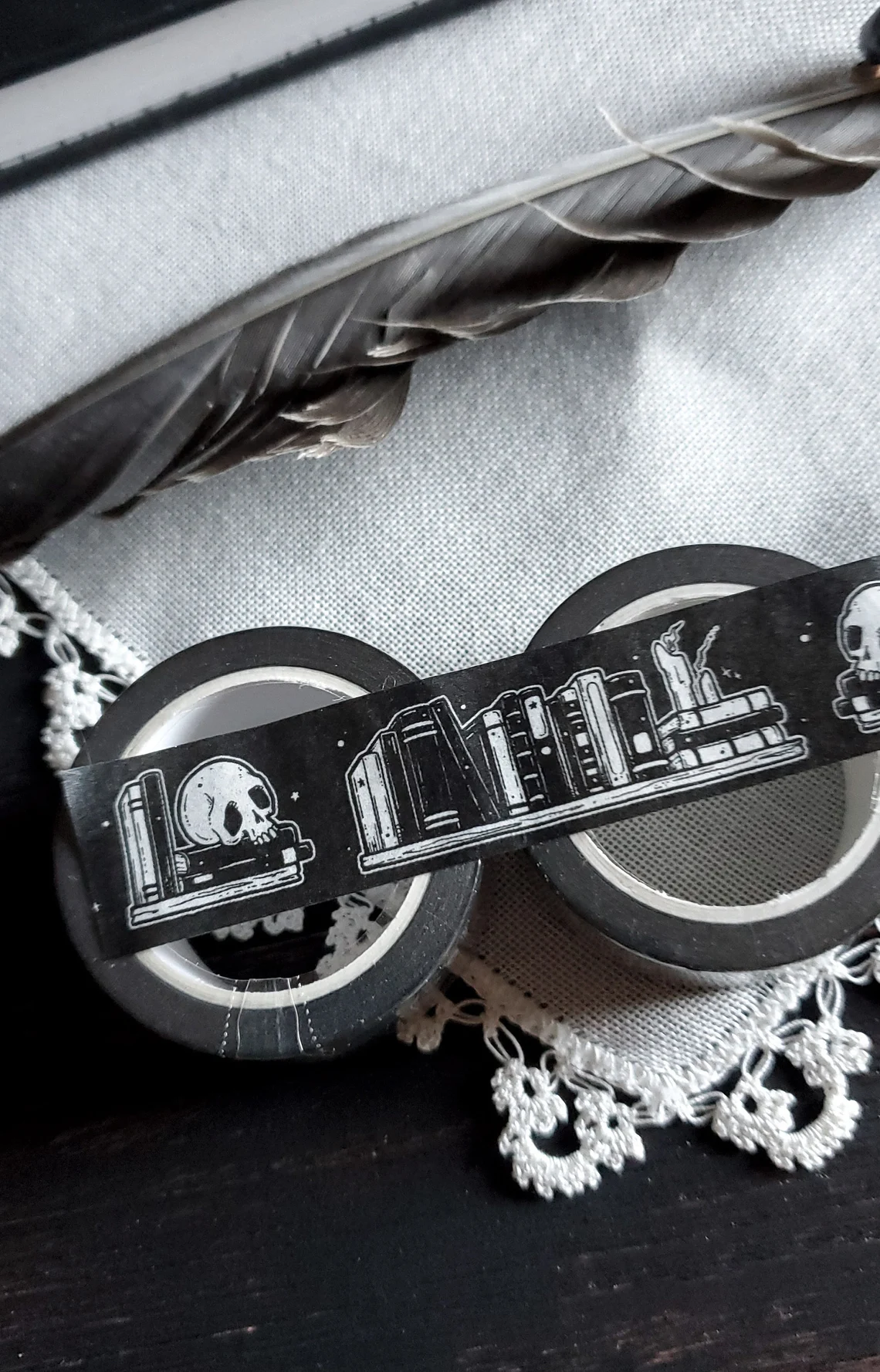 picture of black and white washi tape decorated with skulls, candles, and books  