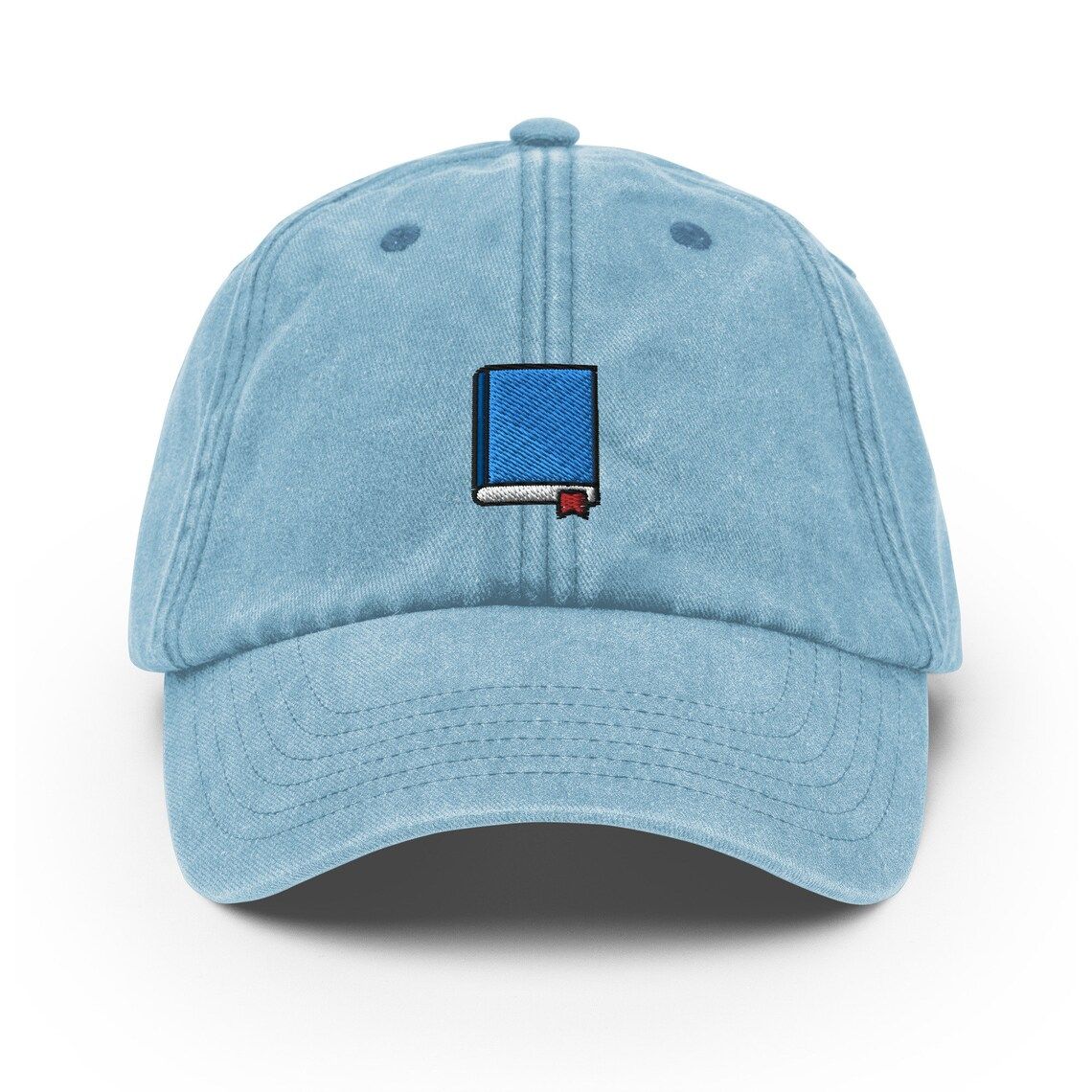 Image of a vintage blue baseball hat with a blue book on it. 