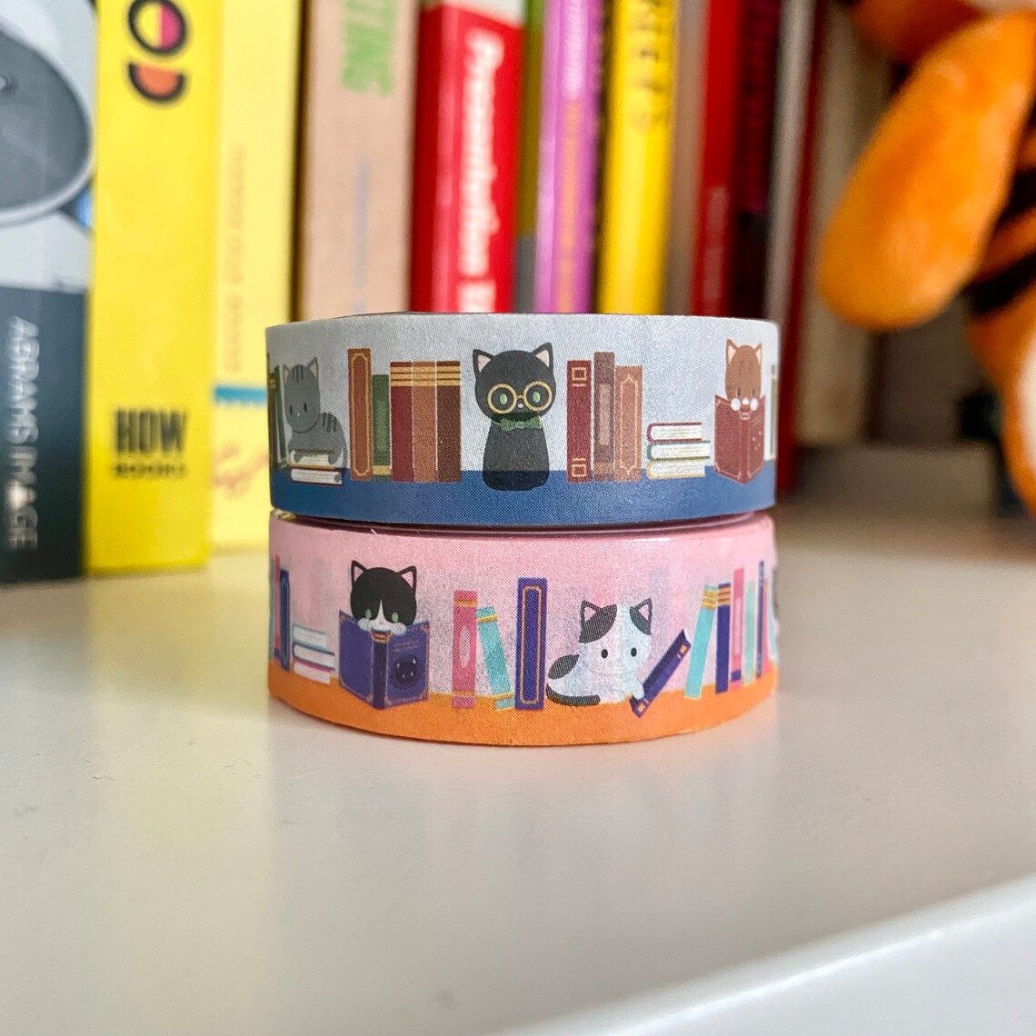 roll of pink and roll of blue washi tape decorated with cats and books