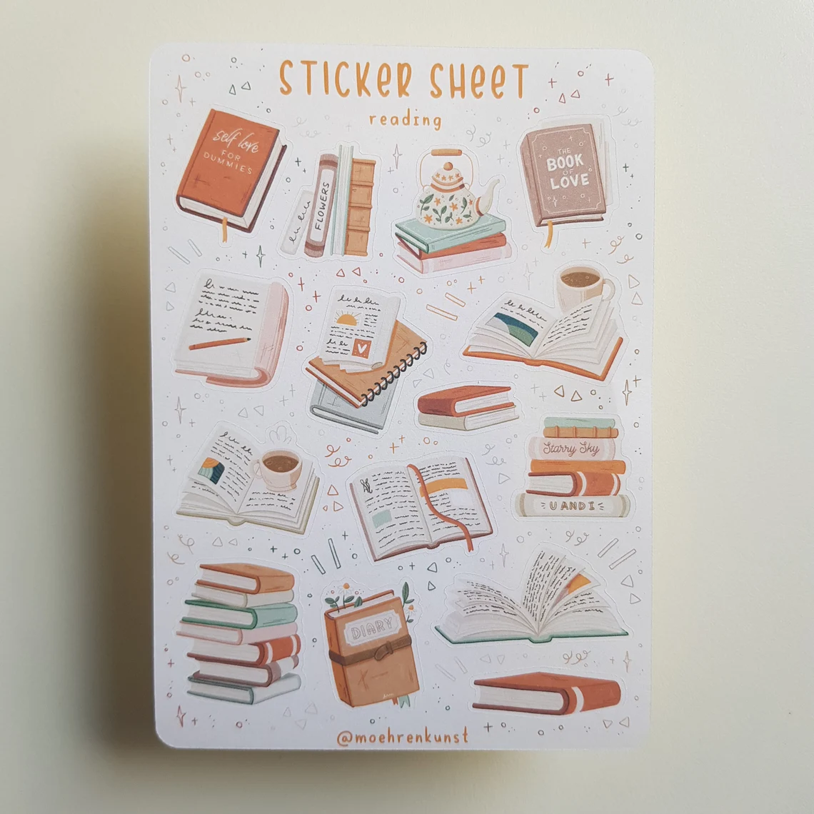 sheet of decorative stickers featuring books and tea cups in dreamy, muted tones 