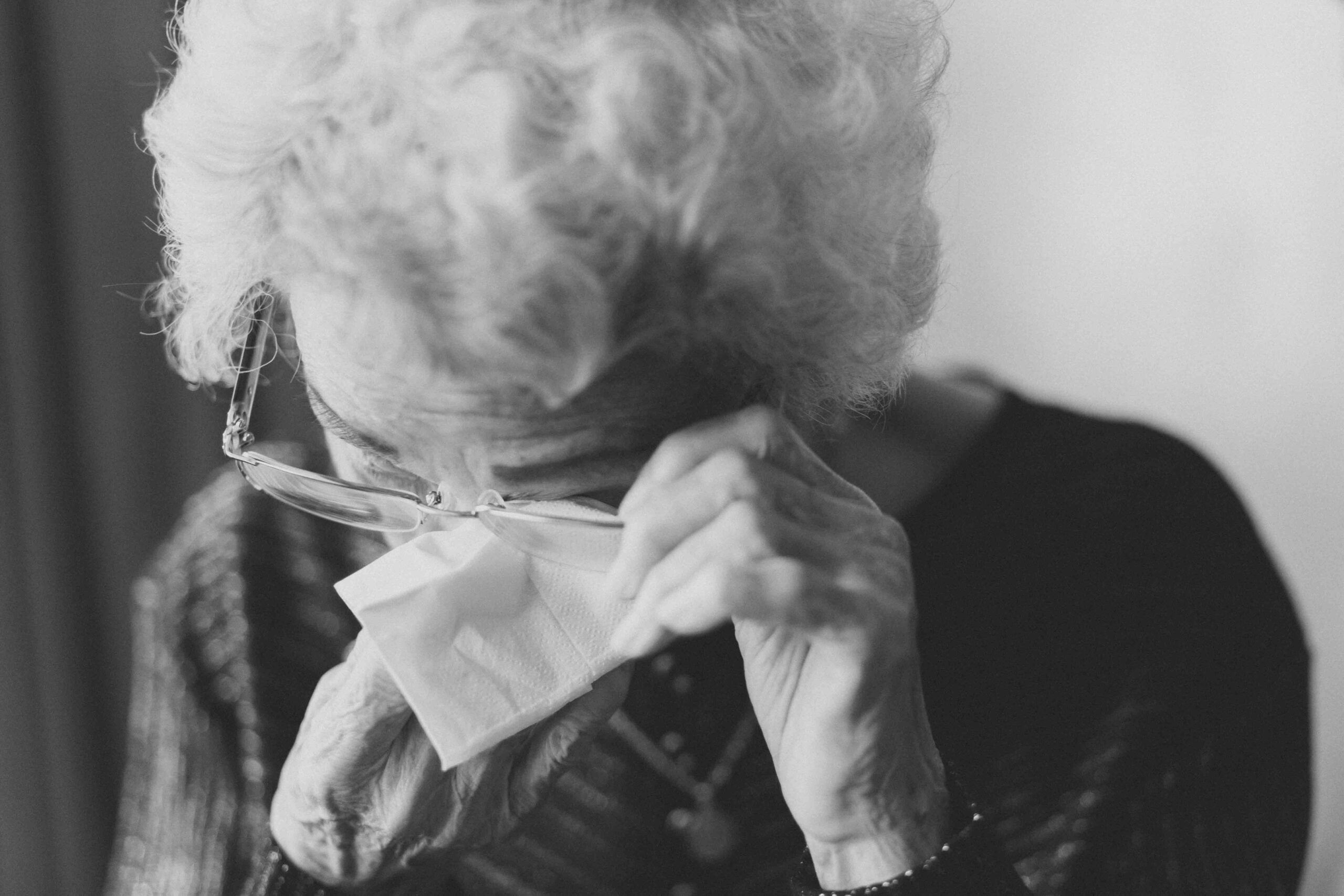 A black and white image of an elderly woman crying