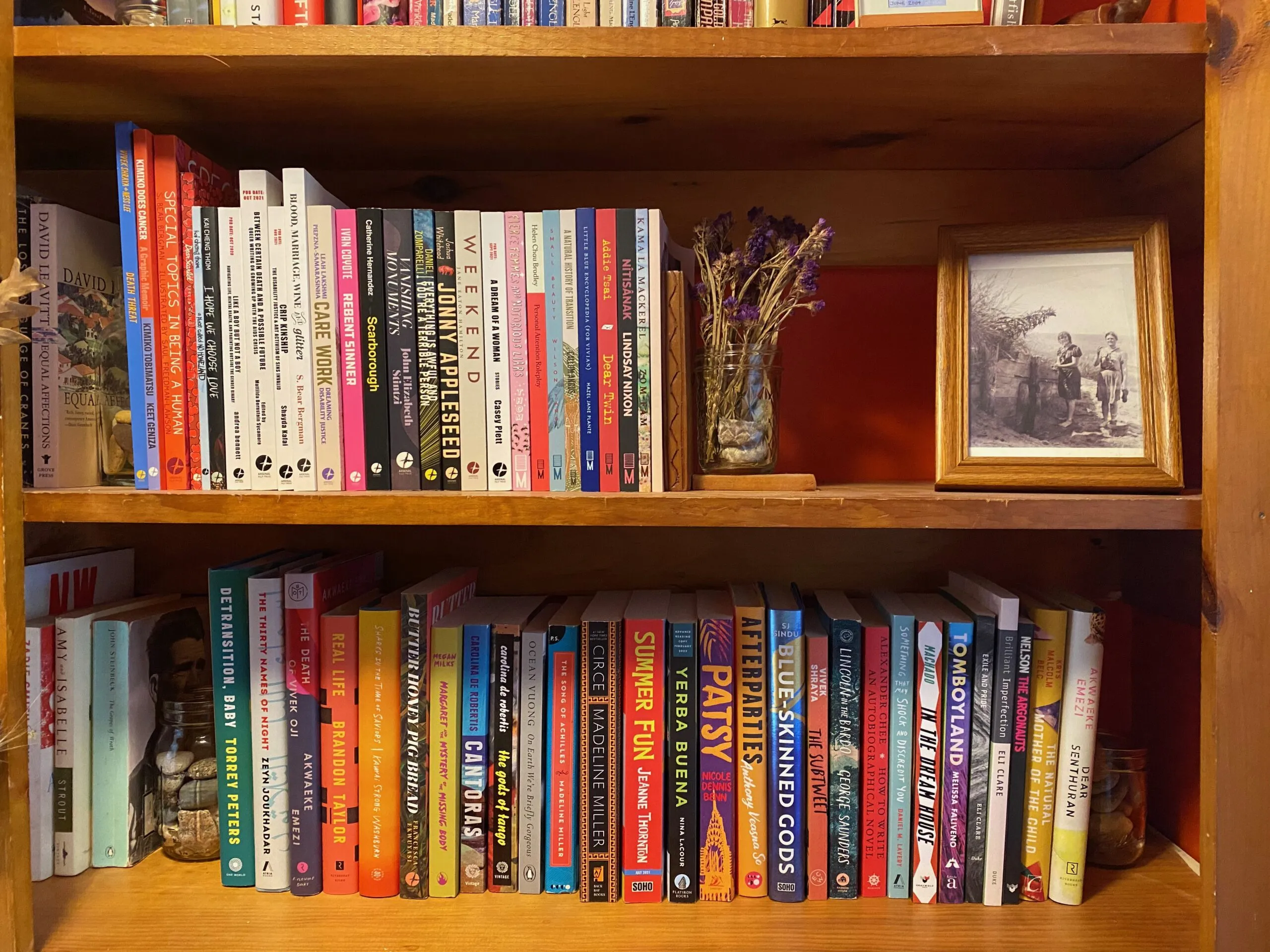 A closeup of two wooden shelves of by colorful books. Photo by the author. 