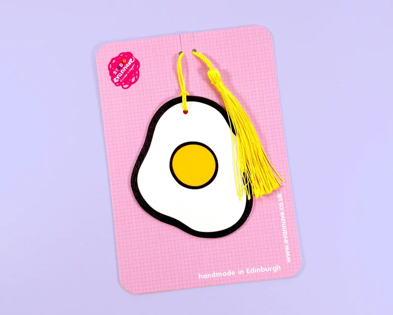 Image of a faux leather bookmark in the shape of a sunny side up egg. 
