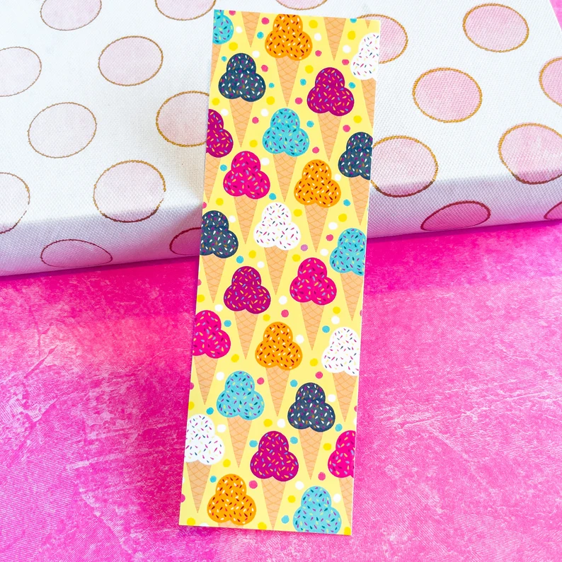 Image of a brightly colored bookmark. The background is yellow and the design is an array of ice cream cones. 