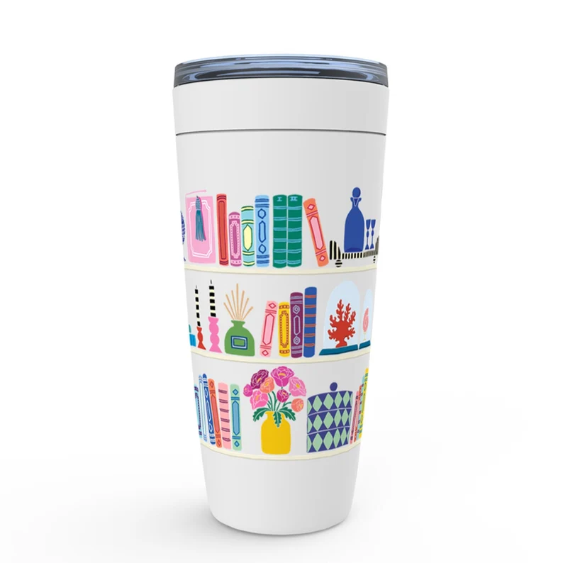 Image of a white tumbler with three bookshelves filled with colorful books and plants. 