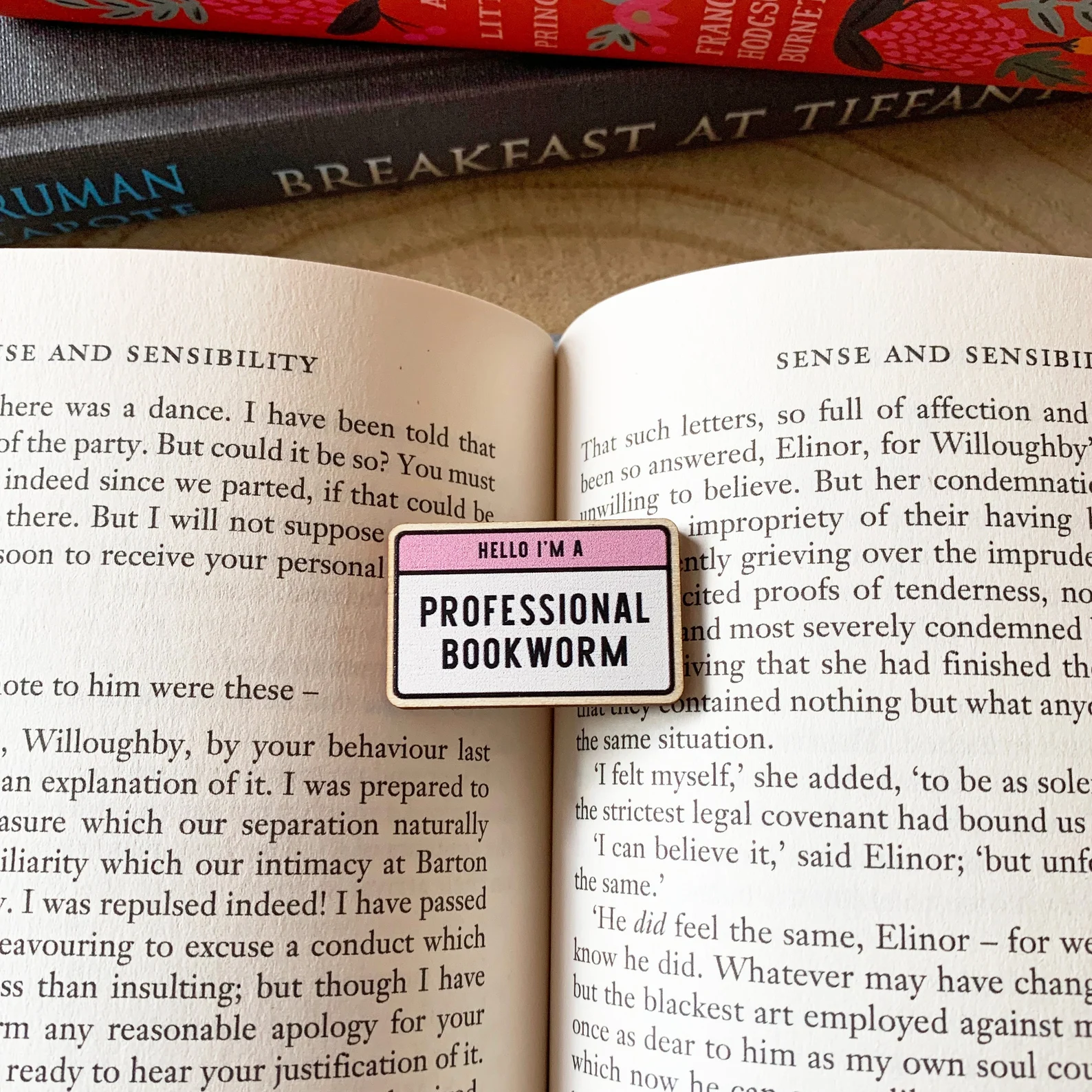 Small wooden pin that reads "Hello, I am a professional bookworm"