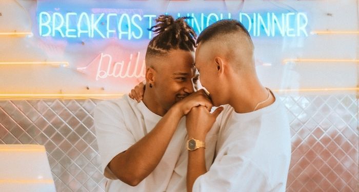 two queer brown people embracing