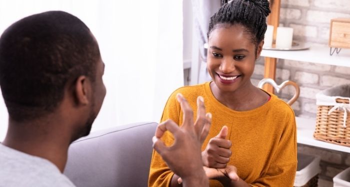 a brown-skinned and and woman communicating with each other in sign language