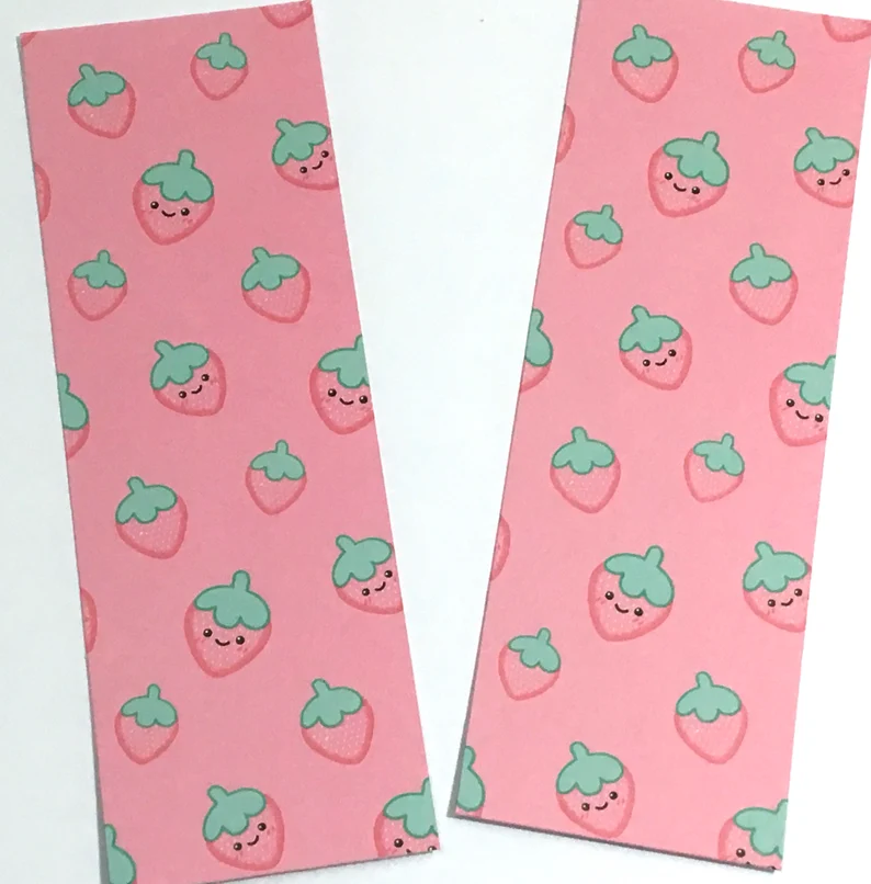 Image of two pink bookmarks with strawberries on them. 