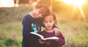 two kids leaning on each other and reading