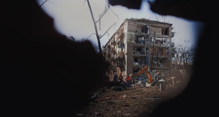 destroyed residential building as viewed from a hole in a wall