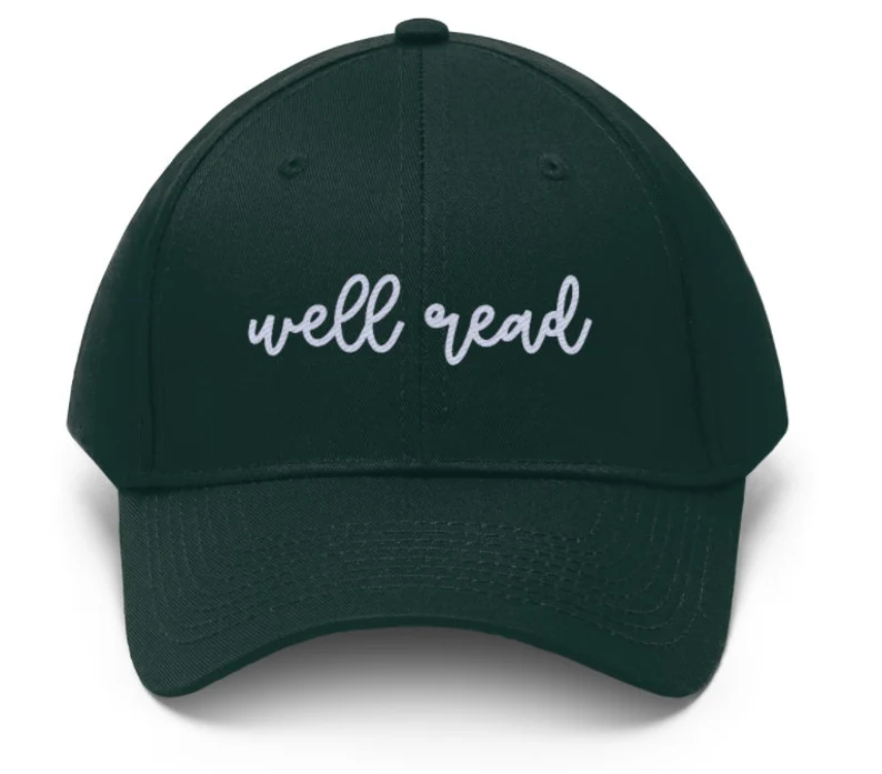 image of a green baseball hat with white curly font that says "well read."