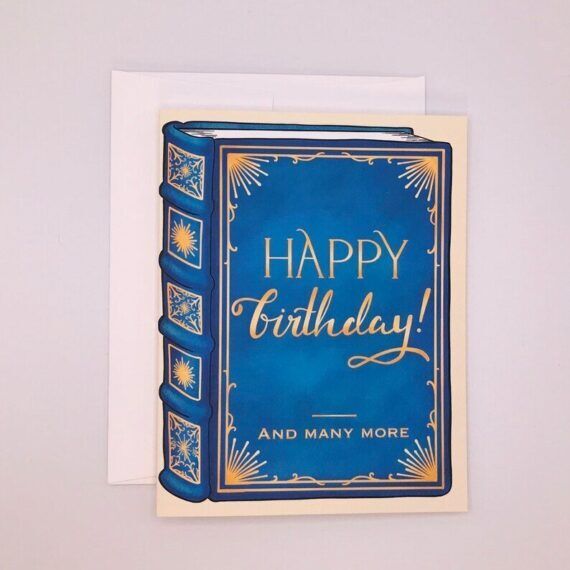 Blue book cover birthday card that says Happy birthday and many more.