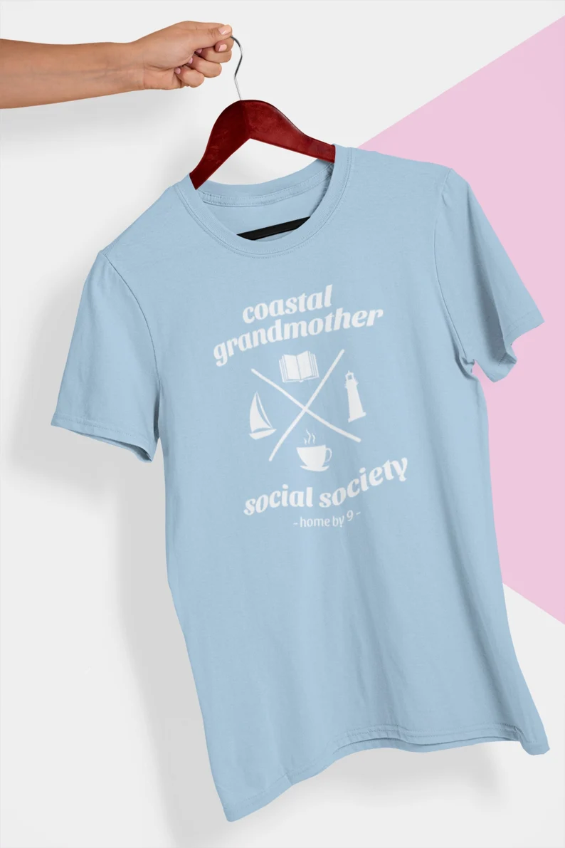 Image of a light blue t-shirt that reads "coastal grandmother social society, home by 9."