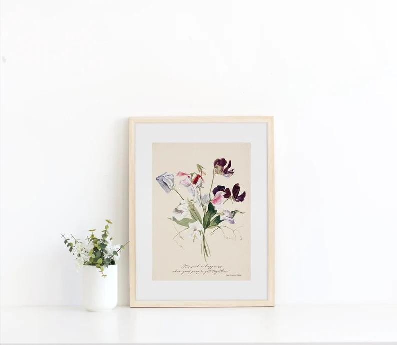 A photo of a wall print containing a quote from Emma and some flowers next to a vase with flowers