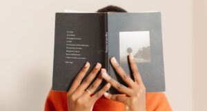 Image of a person with brown hands holding open a book