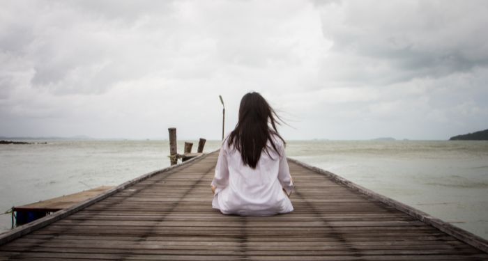 Image of a person with long hair on a pier