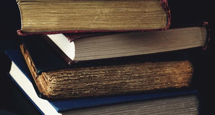 a stack of four old books